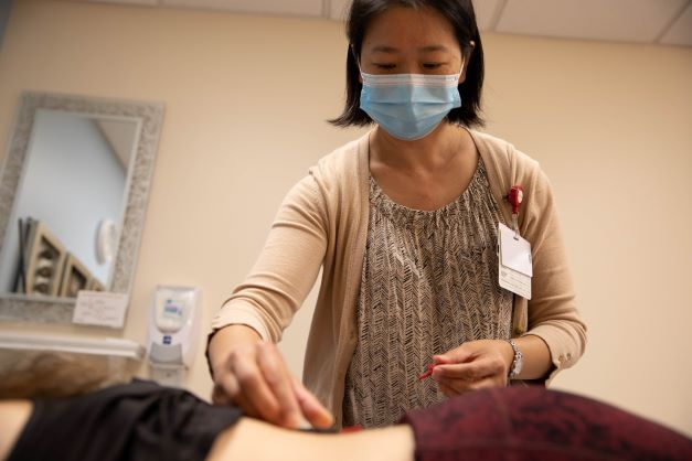 Image of a person performing acupuncture